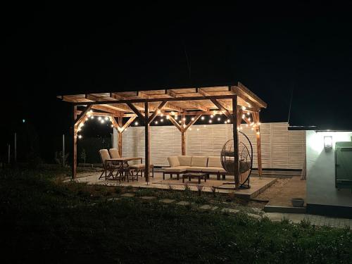 a wooden gazebo with lights on it at night at Makravölgyi Házikó in Csajág