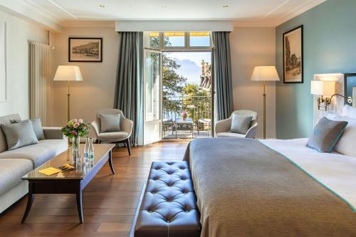 a hotel room with a king sized bed and a living room at Grand Hotel Suisse Majestic, Autograph Collection in Montreux
