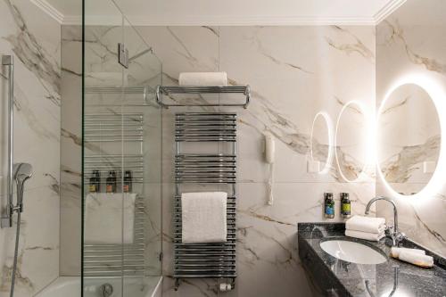 a bathroom with a glass shower and a sink at Grand Hotel Suisse Majestic, Autograph Collection in Montreux