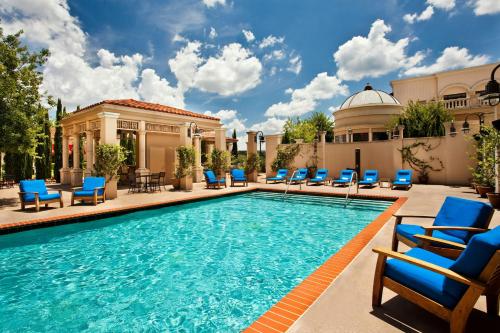 a pool with blue lounge chairs and a building at The Westin Huntsville in Huntsville