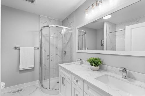 a white bathroom with a shower and a sink at Brand new custom 4BR house in Oshawa