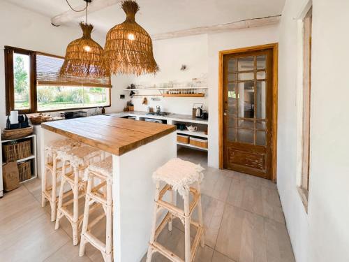 una cucina con un bancone e degli sgabelli di La Sulka a Tafí del Valle