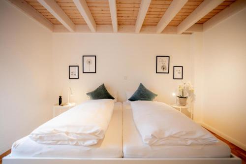 诺德霍恩Dock 2 - tolles Ferienhaus für bis zu 6 Personen mit Kaminofen und Sauna - Haustiere herzlich willkommen的卧室里有一张白色的大床，上面有两个枕头