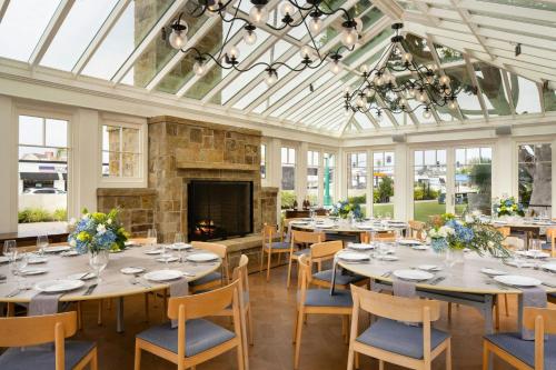 a dining room with tables and chairs and a fireplace at Lido House, Autograph Collection in Newport Beach