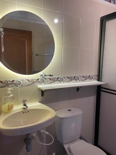 a bathroom with a sink and a toilet and a mirror at Hotel Colonial Abejorral in Abejorral