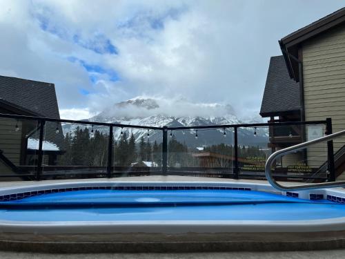 a swimming pool with a view of a snow covered mountain at Utopia at Rundle Cliffs Lodge in Canmore