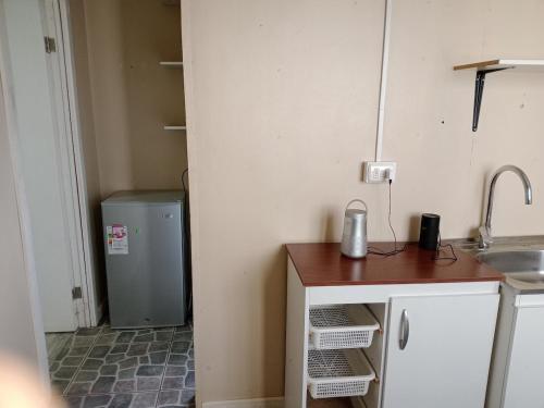 Una pequeña cocina con fregadero y refrigerador. en Cabaña en Valdivia, Chile, en Valdivia