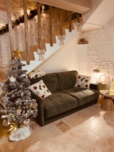 a living room with a green couch and a christmas tree at Parenthèse entre forêt et château in Pierrefonds