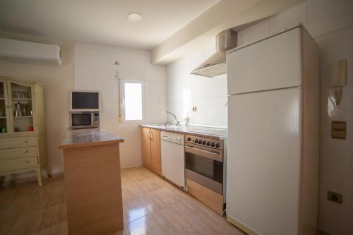 Una cocina con un refrigerador blanco y una estufa. en Apartamento Senda Bardenas Arguedas, en Arguedas