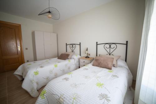 Dos camas una al lado de la otra en un dormitorio. en Apartamento Senda Bardenas Arguedas, en Arguedas