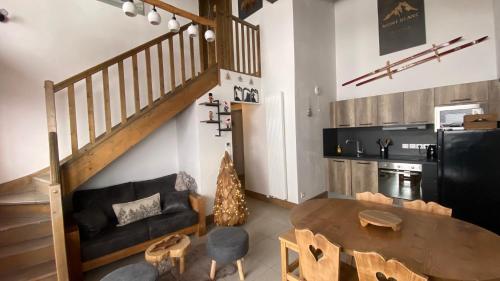 a living room with a table and a kitchen at Les 7 laux immobilier chalet F in Prapoutel