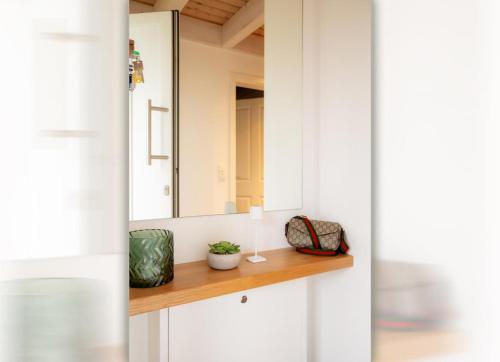 诺德霍恩Dock 2 - tolles Ferienhaus für bis zu 6 Personen mit Kaminofen und Sauna - Haustiere herzlich willkommen的带白色橱柜和镜子的浴室