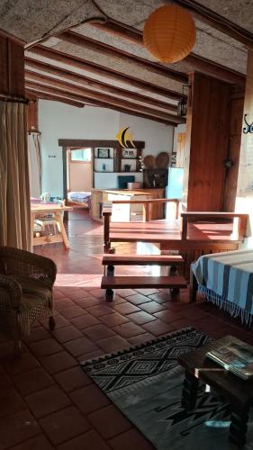 a living room with wooden benches and a kitchen at Vistas espectaculares in Mirasol