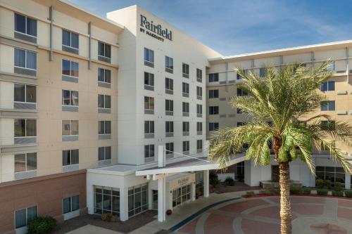 an exterior view of a hotel with a palm tree at Fairfield Inn and Suites Phoenix Chandler Fashion Center in Chandler