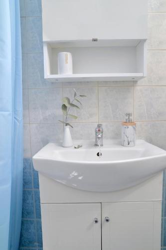 a white bathroom sink with a vase on it at Vottas Seaside House Nea Makri in Nea Makri