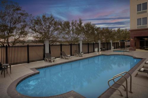 a large swimming pool with chairs and a building at Fairfield Inn and Suites Phoenix Chandler Fashion Center in Chandler