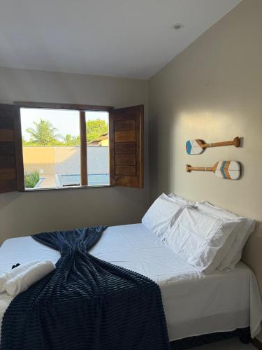 Un dormitorio con una cama grande con ventana. en Pousada Encantos do Litoral, en Maraú