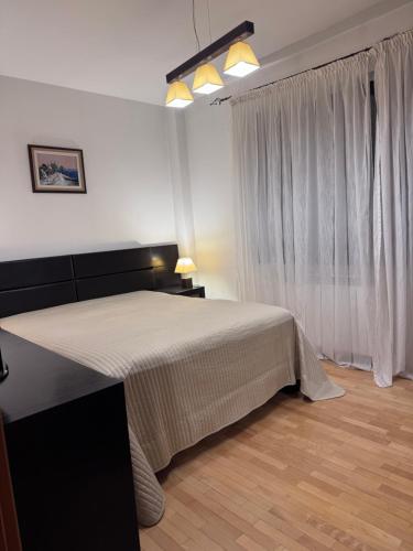 a bedroom with a large bed and a window at La Residenza in Craiova
