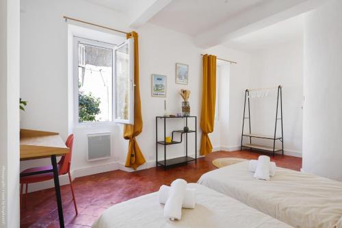 a room with two beds and a window at Oustau de Gemo - Maison confort au cœur de Gémenos in Gémenos