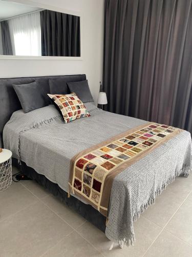 a bedroom with a bed with a quilt on it at CoveDream Studio Cove Garden Sun Valley Esentepe in Aglantzia
