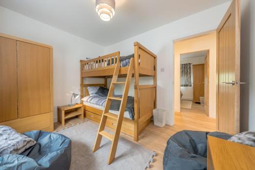 a bedroom with two bunk beds and a ladder at Adwyr-Mynydd in Dinorwic