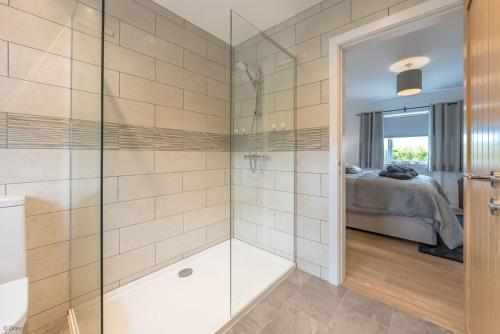 a bathroom with a shower with a glass door at Adwyr-Mynydd in Dinorwic