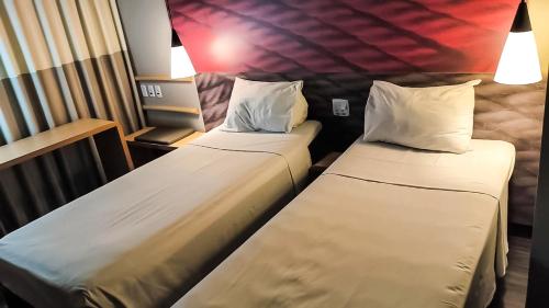 タトゥイーにあるibis Tatuiの宣伝付きの2つのベッドのあるホテルの部屋