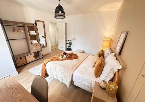 a bedroom with a bed and a table and a mirror at Fleur Bohème - Hypercentre République - Parking in Le Mans