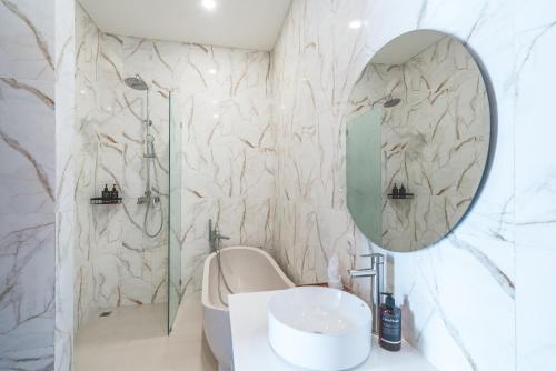 a bathroom with a shower and a sink and a mirror at Villa Kusuma 3 Seminyak in Badung