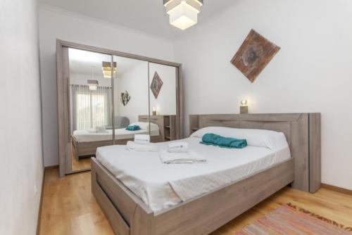 a bedroom with a large bed and a mirror at B81 - Casa do Outeiro Westcoast Home in Vila do Bispo