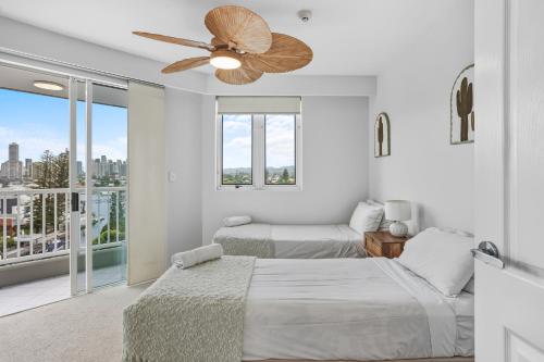 una camera da letto con due letti e un ventilatore a soffitto di Quiet location close to it all a Gold Coast
