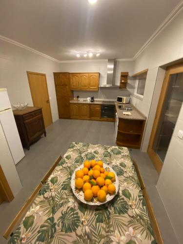 a bowl of oranges on a table in a kitchen at Casa do Mosteiro in Cabeceiras de Basto