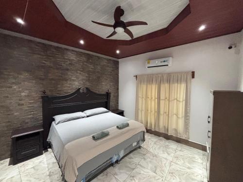 um quarto com uma cama e um ventilador de teto em Casa Amelia, 5 minutes from the airport em Flores