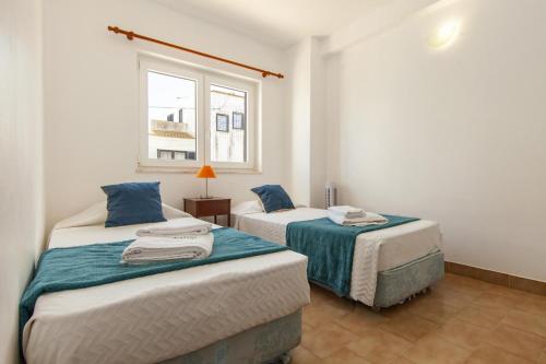 two beds in a room with a window at C06 - Water Tower Townhouse in Lagos
