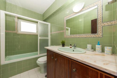 a bathroom with a sink and a toilet and a mirror at C06 - Water Tower Townhouse in Lagos