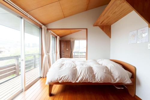 a bedroom with a bed and a large window at SEBARI casa vacation rental in Kushima