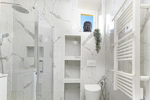 um banheiro branco com chuveiro e vaso sanitário em 3P Monaco avec parking em Saint-Antoine