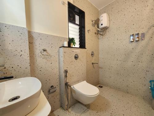 Premium 1BHK Beachside Apartment - Pool, Full Kitchen & Balcony, Candolim في كاندوليم: حمام مع مرحاض ومغسلة