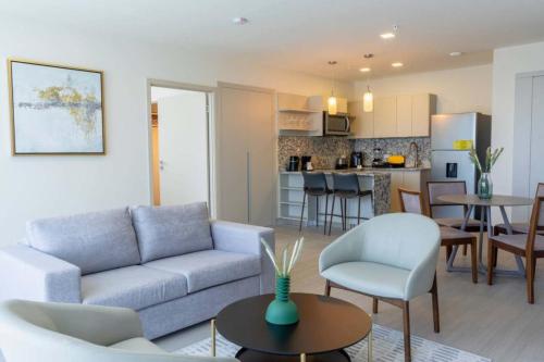 a living room with a couch and a kitchen at Stylish 1-BR with Pull Out Couch and Ocean & City Views in Panama City in Panama City