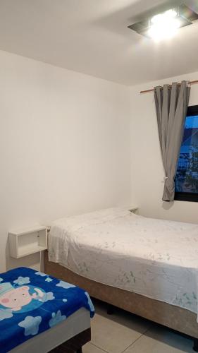 a bedroom with two beds and a window at Ótima casa Jardim do Éden - Tramandaí, poucos passos do mar! in Tramandaí