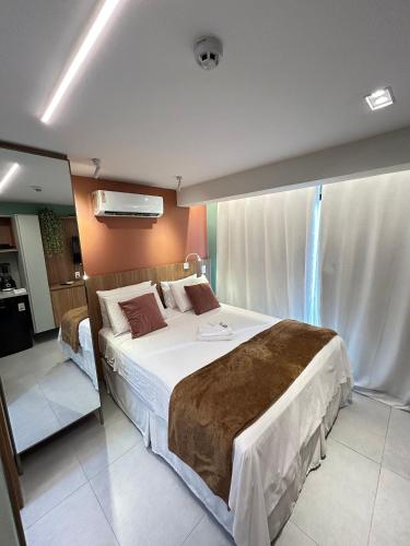 Postel nebo postele na pokoji v ubytování Melhores Flats - Seu desejo, pé na areia