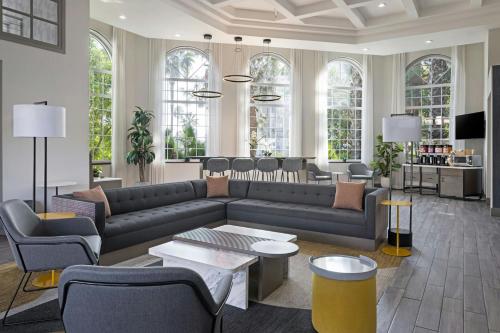 a living room with a couch and tables and chairs at City Express by Marriott Santa Ana/Orange County Airport in Santa Ana