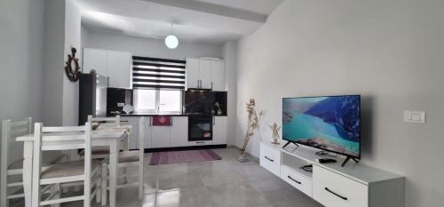 een woonkamer met een tv en een tafel en een keuken bij PERLA 9- Golem Best apartment in Golem