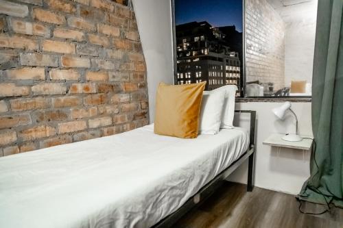 a bed in a room with a brick wall at Cosmic Leopard in Cape Town