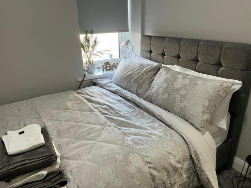 a bedroom with a bed with a gray headboard at Aurora House 2B Warrenpoint in Newry