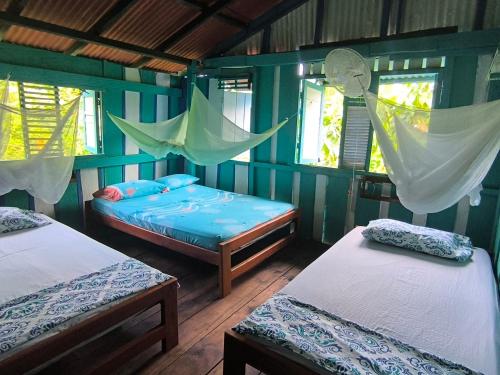 カプルガナにあるLa Bohemia Capurganáのベッド2台とハンモックが備わる客室です。