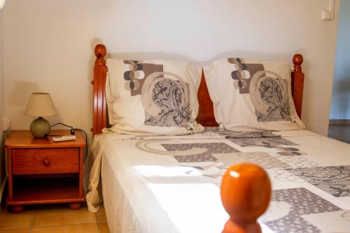 a bedroom with a bed and a table with a lamp at Gîtes les fleurs du bananier in Goyave
