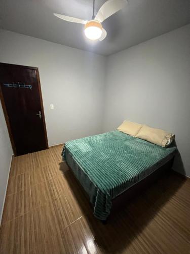 Un dormitorio con una cama y un ventilador de techo. en Ampla casa em Porto Belo com fácil acesso à Zimbros, en Porto Belo