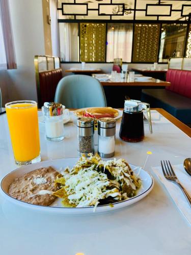 une assiette de nourriture sur une table avec du jus d'orange dans l'établissement Hotel Colonial Mexicali, à Mexicali