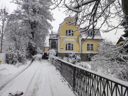 una strada innevata davanti a una casa gialla di Retro Apartment 120 m2 a Szczawno-Zdrój